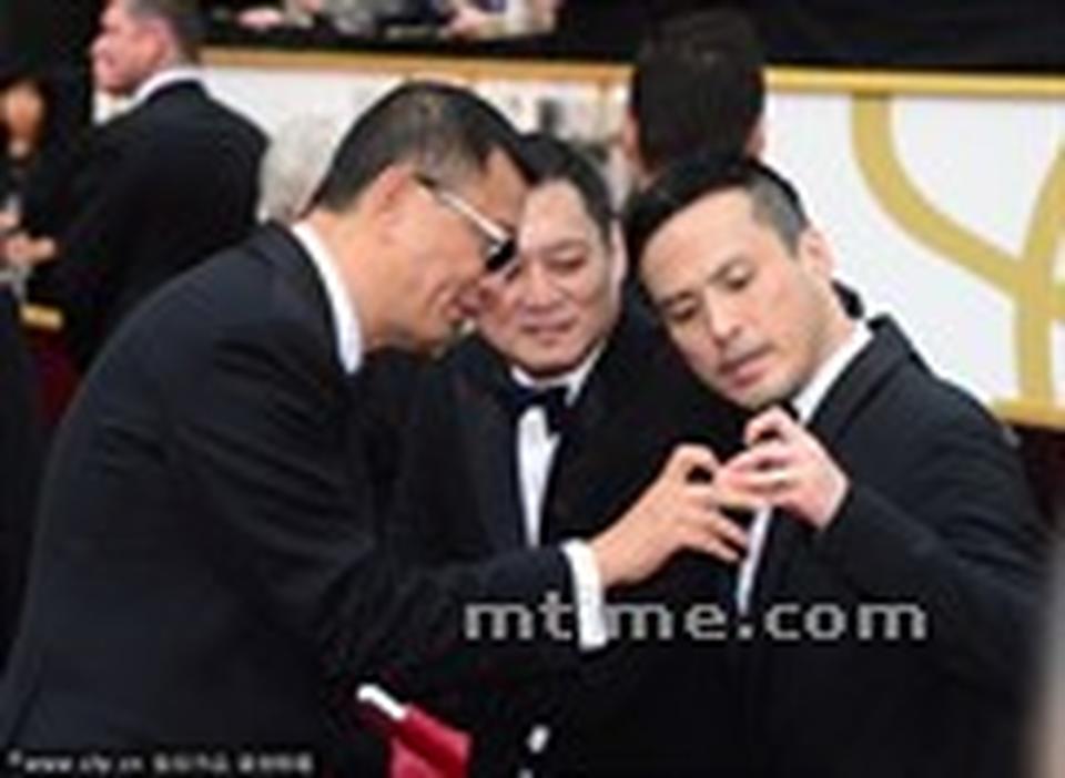 王家卫与他的团队走红毯不忘玩手机