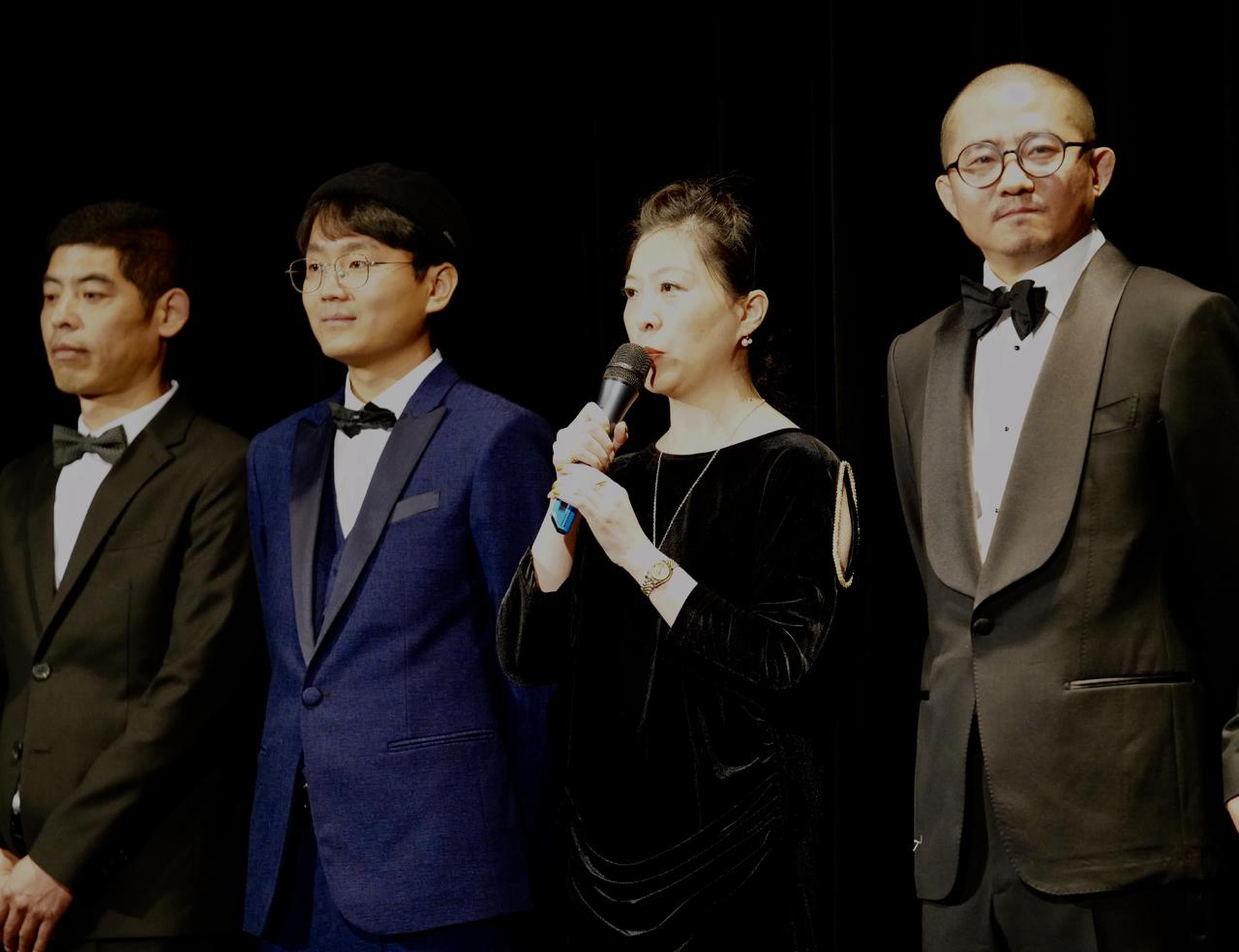 总制片人、大地电影总经理：张群，在首映礼上致辞，左二为导演顾晓刚，左一为饰演三伯的演员：孙章建，右为出品人总制片人，工厂大门影业CEO：黄旭峰